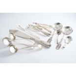 A MIXED LOT:- A pair of engraved sugar tongs by Hester Bateman, two other pairs of sugar tongs, a