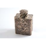 AN EARLY 20TH CENTURY GERMAN DECORATIVE TEA CADDY with a pull-off cap, embossed & chased on one side