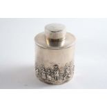 AN EDWARDIAN CYLINDRICAL TEA CADDY with a pull-off cap and embossed decoration around the lower