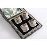 A LATE VICTORIAN CASED SET OF FOUR NAPKIN RINGS with chased decoration, numbered "1", "2", "3" & "