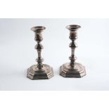 A PAIR OF LATE 20TH CENTURY CANDLESTICKS in the early 18th century style on canted square bases, one