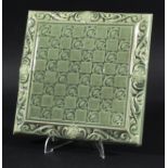 LEEDS FIRECLAY ART NOUVEAU TILE - BURMANTOFT a draught board pottery tile with a green glaze, with