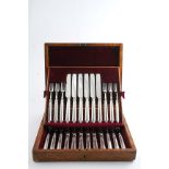 AN EDWARDIAN CASED SET OF TWELVE PAIRS OF FRUIT/DESSERT KNIVES & FORKS with loaded handles, by