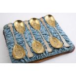 A VICTORIAN CASED SET OF SIX PARCELGILT FRUIT SERVING SPOONS with chased & embossed decoration, by