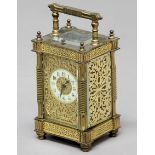 FRENCH GILT BRASS FOUR PANE CARRIAGE CLOCK, the ivorine dial inside a scrolling gilt frame, on an