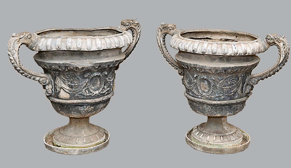 PAIR OF LEAD URNS AND STANDS, 18th century and later, the gadrooned bodies with dolphin handles,