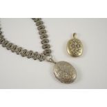A VICTORIAN METAL PENDANT AND CHAIN with engraved decoration, together with another locket pendant