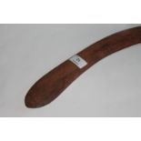 A BOOMERANG. A Boomerang with geometric carvings, having the elongated throwing arm. 30.1/2" in