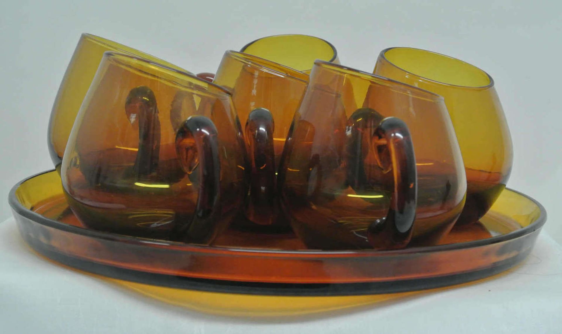 60er Jahre Gläser, ausgefallene schräg abgeschliffene honigfarbe Rauchgläser auf einem