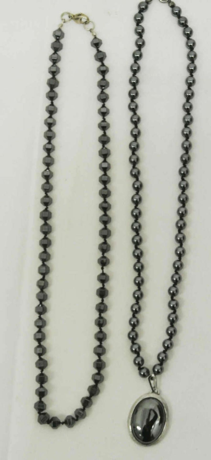 2 Hämatitketten. 1x mit Silberanhänger, 835er gepunzt. 2 hematite chains. 1x with silver pendant,