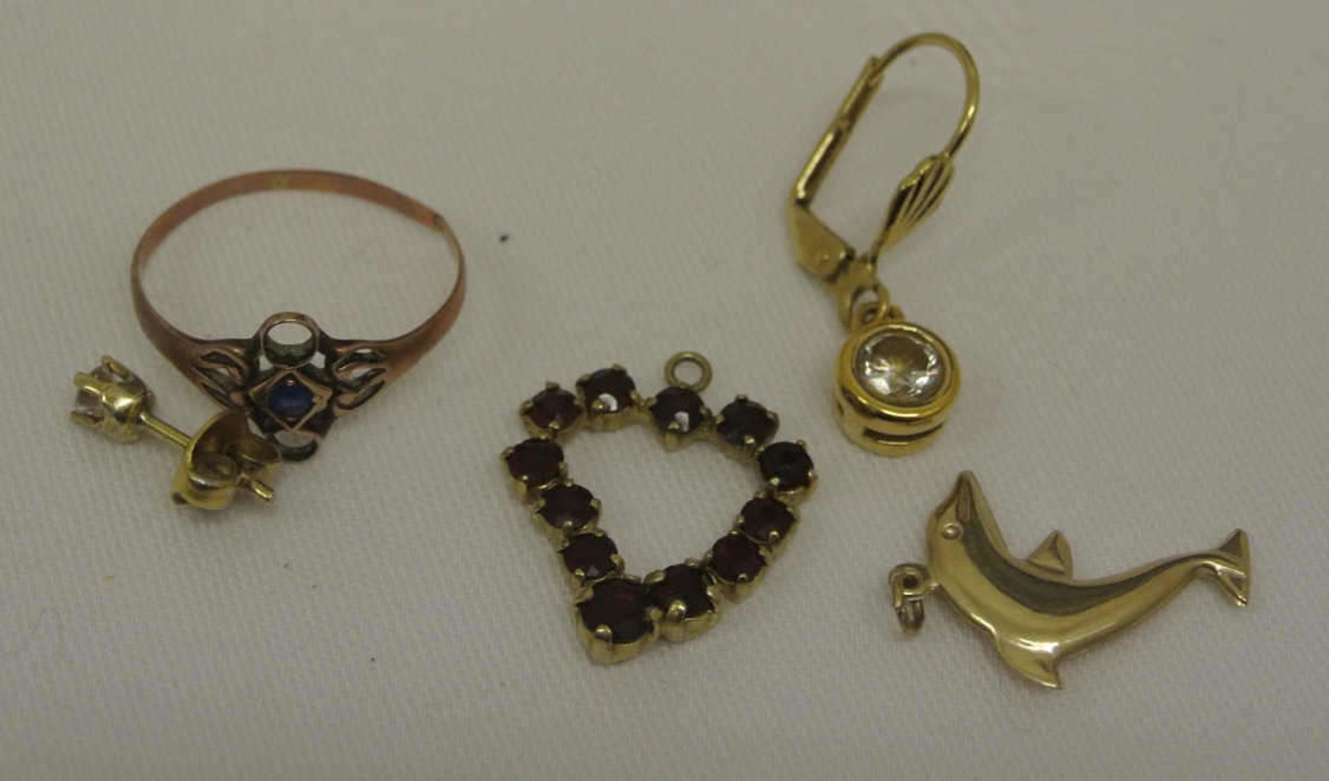 Kleines Lot Goldschmuck, bestehend aus 1 Ring, 1 Anhänger "Delfin", 1 Anhänger "Herz" mit Granaten