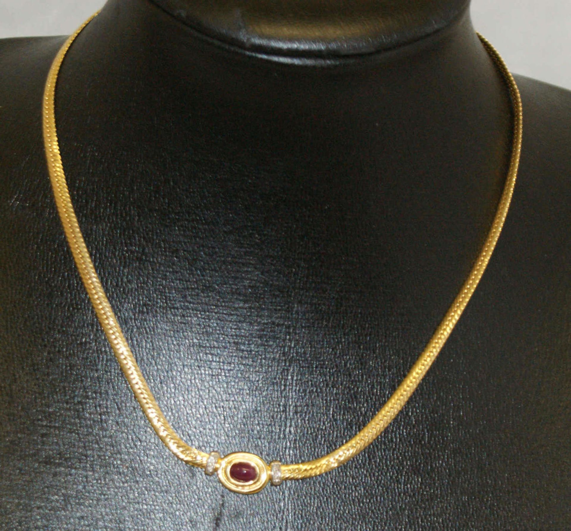 Collier, 585er Gelbgold, mittig besetzt mit 1 Sternrubin flankiert von kleinen Brilliantsplittern.