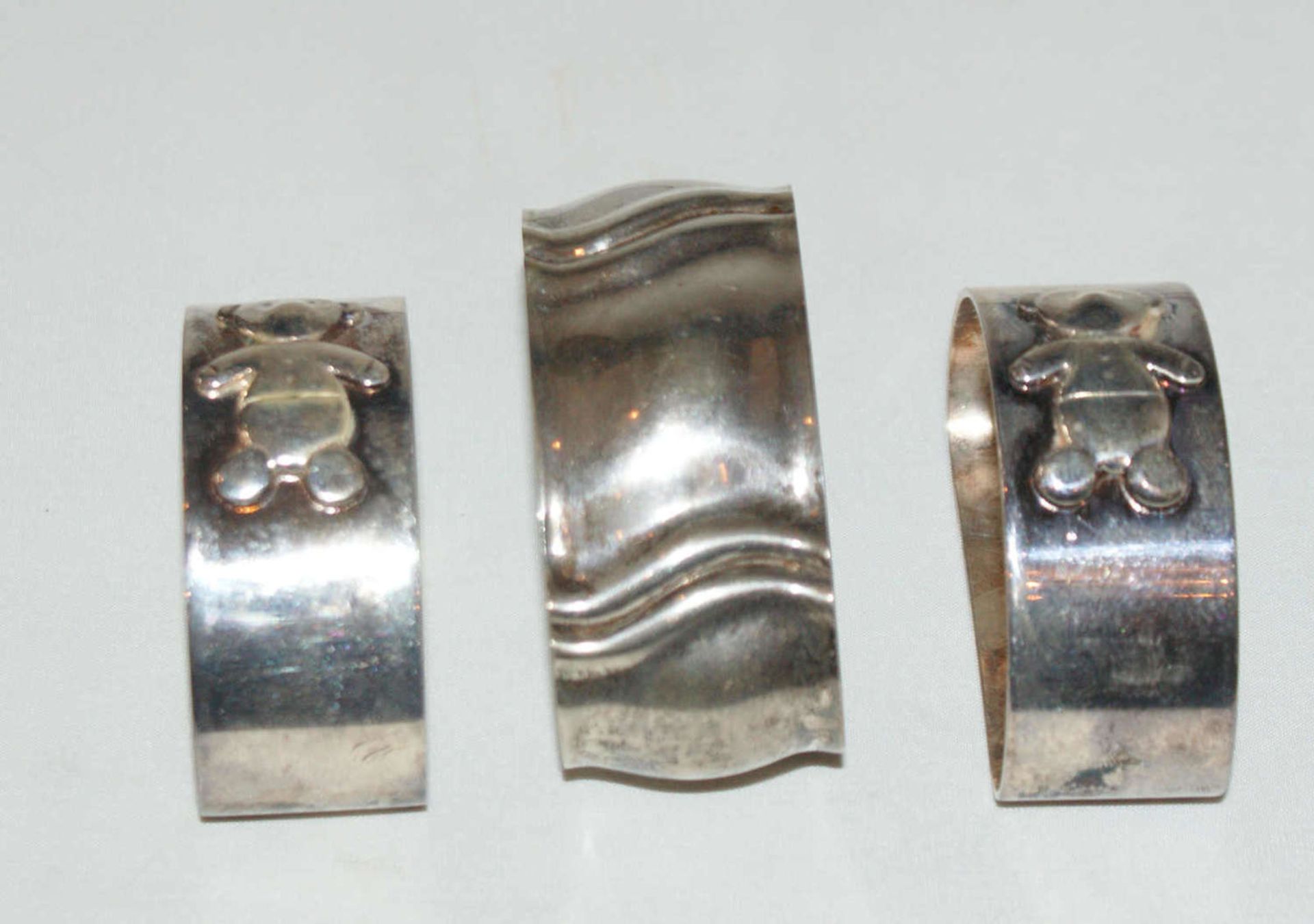 3 Serviettenringe, Silber, Gewicht ca. 91,3 gr. 2 Serviettenringe mit Bärchen verziert.