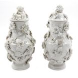 A Pair of Vienna Blanc-de-Chine Porcelain Urns and Covers Height 13 1/2 inches.