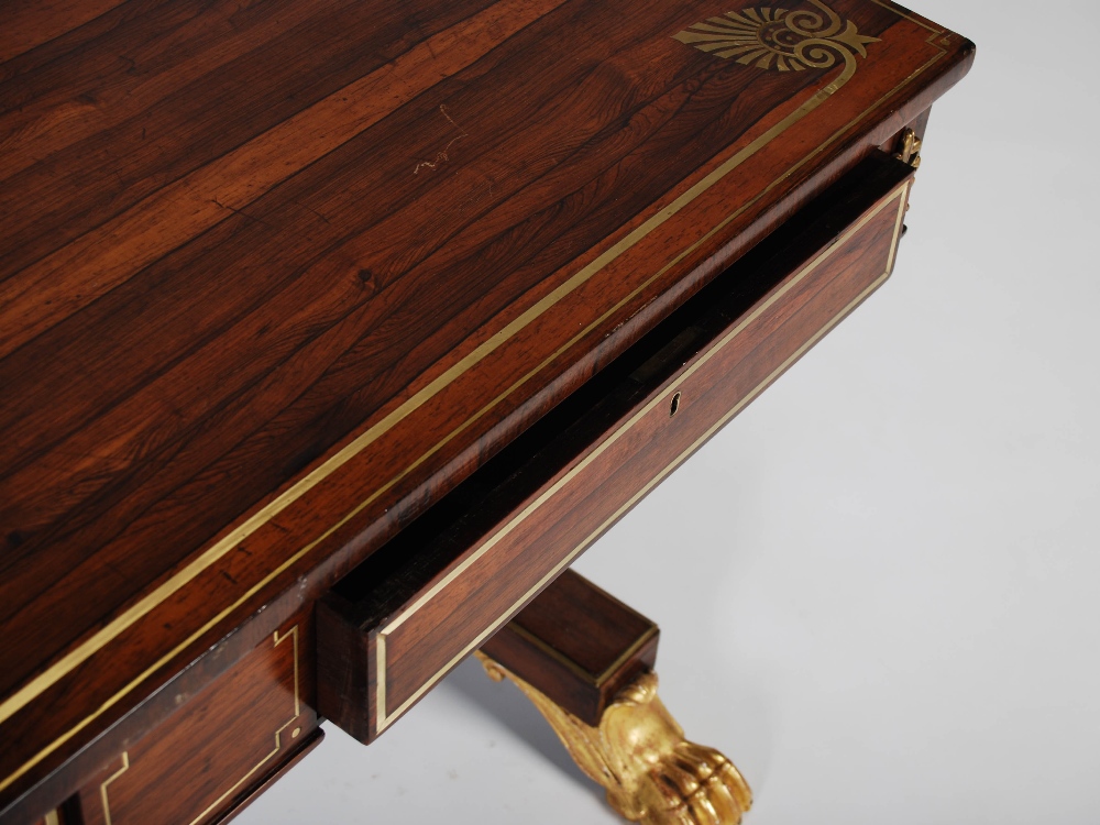 A Regency rosewood, brass inlaid and gilt wood library table, the rectangular top with a brass - Image 6 of 7