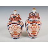 A pair of late 19th/early 20th century Japanese Imari jars and covers, decorated with rectangular