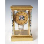 A late 19th/early 20th century French gilt metal and champleve enamel mantel clock, the circular