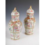 A pair of Chinese porcelain famille rose Canton jars and covers, Qing Dynasty, decorated with panels