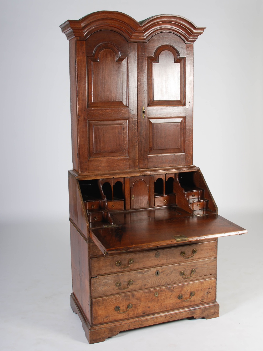 A George III oak bureau bookcase, the double domed moulded cornice above a pair of panelled cupboard - Image 2 of 6