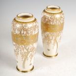 A pair of Japanese Satsuma pottery vases, Meiji period, decorated with blossom, trees and