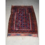 An antique blue ground prayer mat, the central mirhab shaped panel enclosing four rows of stylised