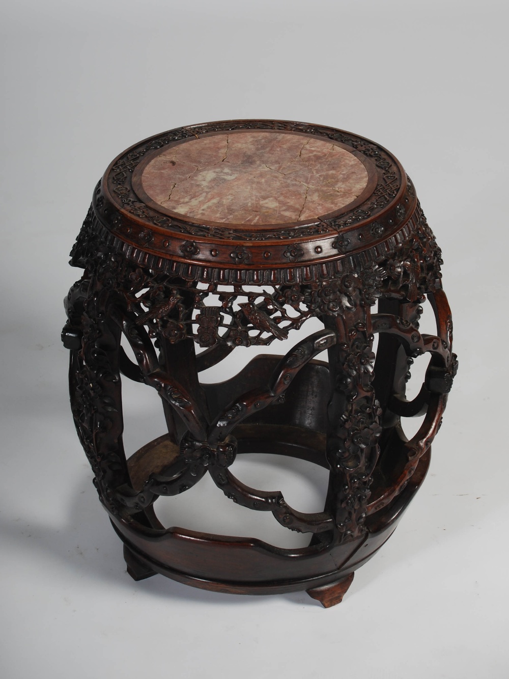 A Chinese dark wood barrel shaped jardiniere stand, Qing Dynasty, the circular top with a mottled