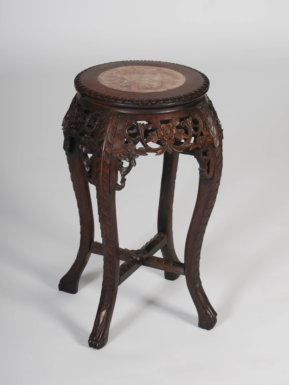 A Chinese dark wood jardiniere stand, late Qing Dynasty, the circular top with a mottled red