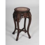 A Chinese dark wood jardiniere stand, late Qing Dynasty, the circular top with a mottled red