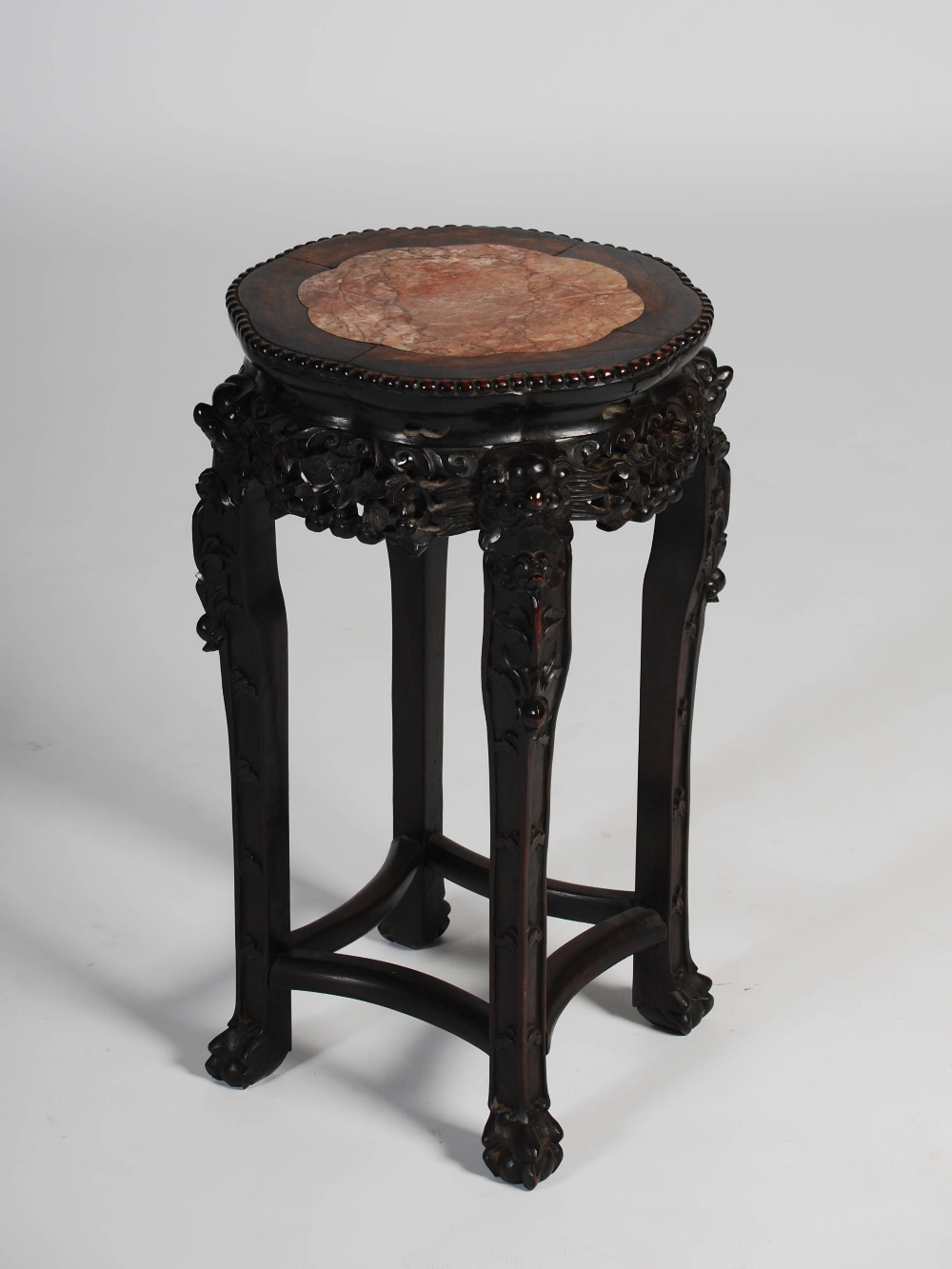 A Chinese dark wood jardiniere stand, late Qing Dynasty, the shaped octagonal top with a mottled red