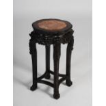 A Chinese dark wood jardiniere stand, late Qing Dynasty, the shaped octagonal top with a mottled red