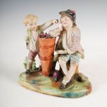 A late 19th/early 20th century Bisque porcelain figure group, modelled with two boys either side