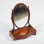 A 19th century mahogany and boxwood lined dressing table mirror, the oval mirror plate on a