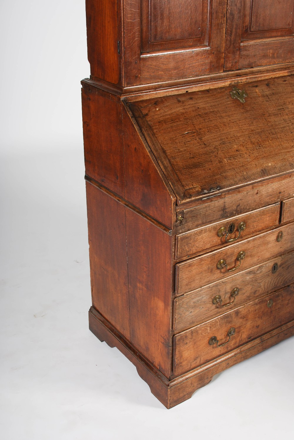 A George III oak bureau bookcase, the double domed moulded cornice above a pair of panelled cupboard - Image 4 of 6