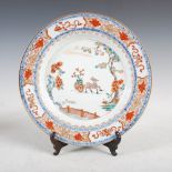 A Chinese porcelain Imari plate, Qing Dynasty, decorated with stag pulling cart in a fenced garden