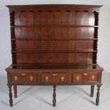 An 18th century and later oak dresser, the upright back with moulded cornice above four open