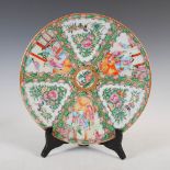 A Chinese porcelain famille rose Canton charger, Qing Dynasty, decorated with panels of figures on