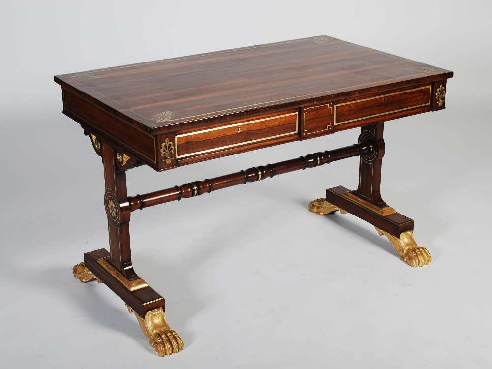 A Regency rosewood, brass inlaid and gilt wood library table, the rectangular top with a brass