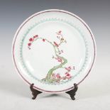 A Chinese porcelain famille rose plate, Qing Dynasty, decorated with prunus blossom branch within