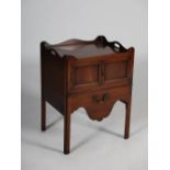 A George III mahogany tray top commode, the rectangular top with kidney shaped cut out handles,