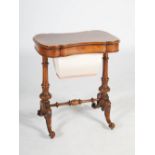A Victorian walnut work table, the shaped rectangular top opening to a fitted interior with three