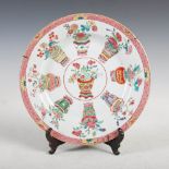 A Chinese porcelain famille rose plate, Qing Dynasty, the central roundel decorated with a