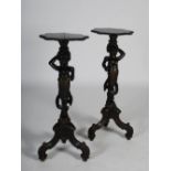 A pair of late 19th/early 20th century carved and stained wood blackamoor torcheres, the shaped