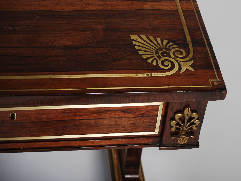 A Regency rosewood, brass inlaid and gilt wood library table, the rectangular top with a brass - Image 5 of 7