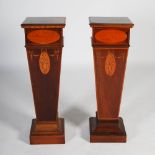 A near pair of Edwardian mahogany and marquetry inlaid pedestals, the square tops above oval