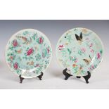 A pair of Chinese porcelain celadon ground famille rose plates, Qing Dynasty, decorated with