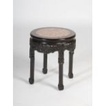 A Chinese dark wood jardiniere stand, late Qing Dynasty, the circular top with a mottled red and