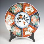 A Japanese porcelain Imari charger, decorated with a central roundel enclosing foliate spray