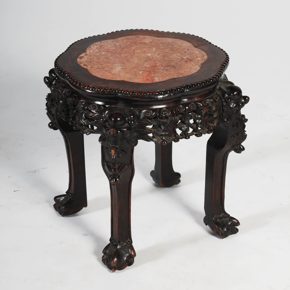 A Chinese dark wood jardiniere stand, late Qing Dynasty, the shaped octagonal top with a mottled red