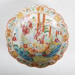 A Chinese porcelain famille rose Canton bowl, Qing Dynasty, the scalloped rim enclosing a circular