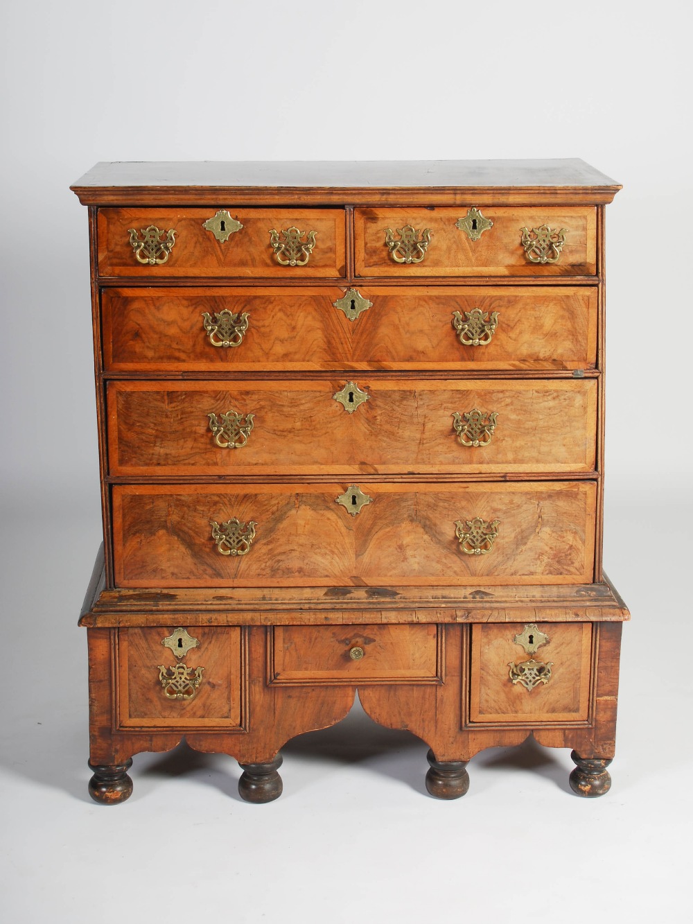 A William & Mary walnut chest on stand, the rectangular top with moulded edge above two short and